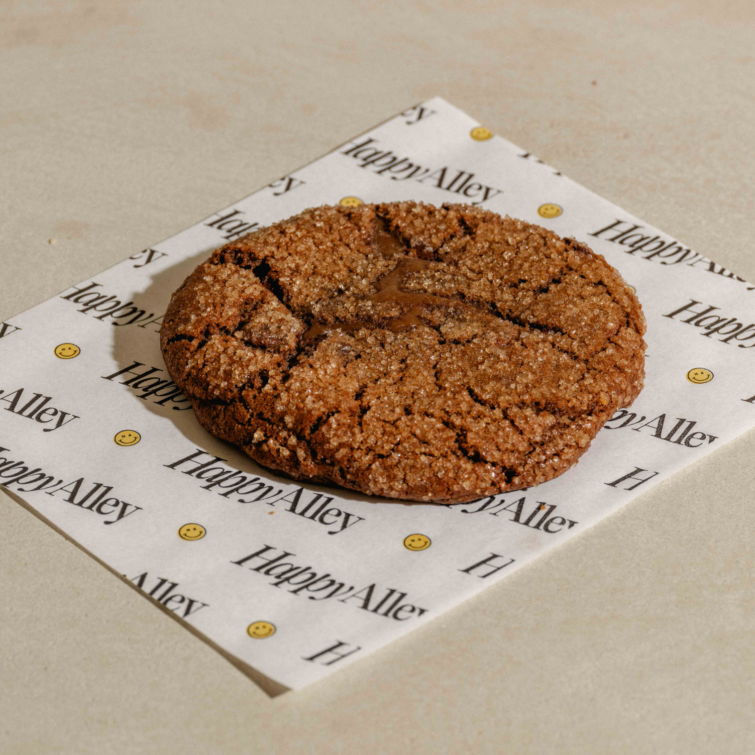 Happy Alley Hazelnut Latte Cookie on a branded paper on a beige surface
