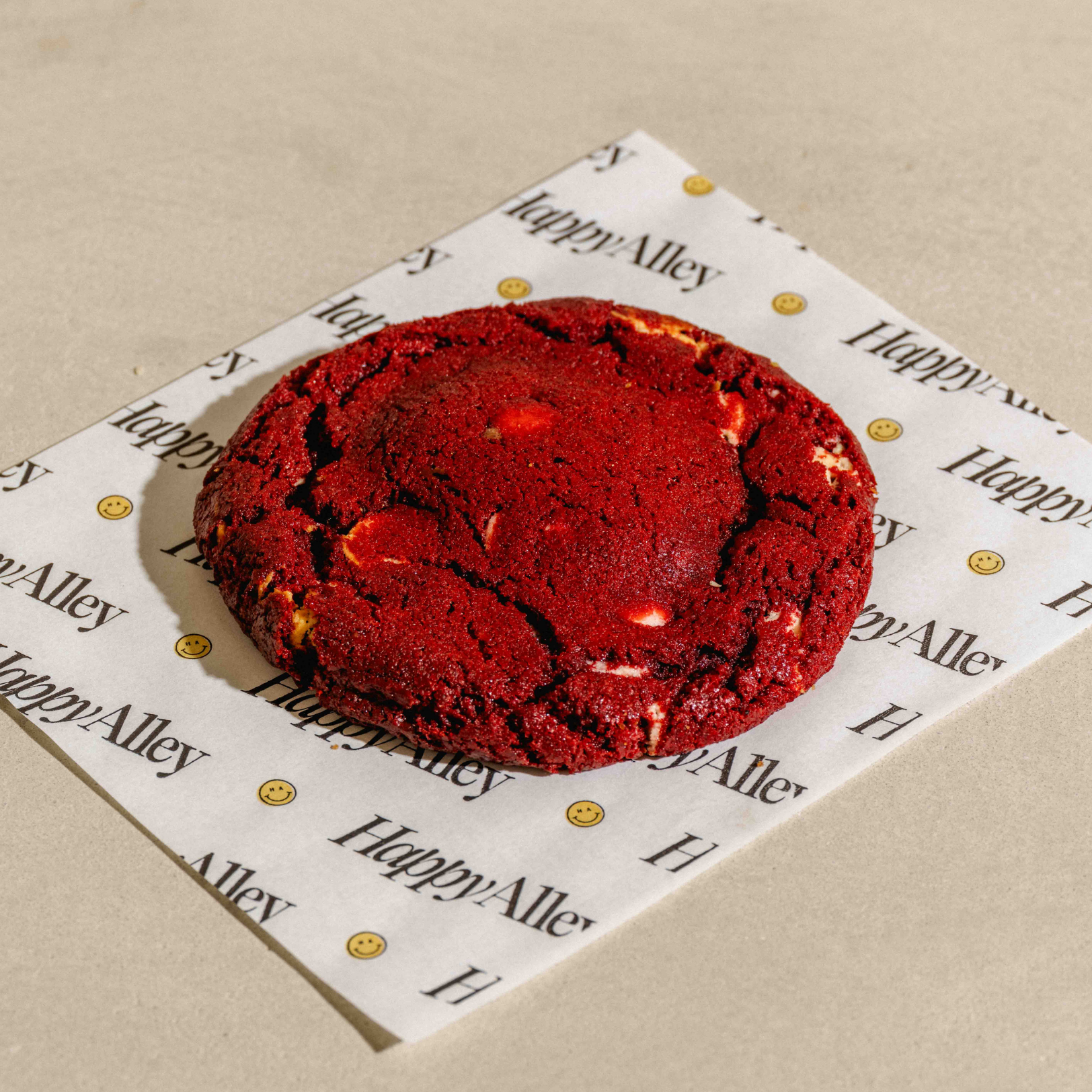 Red Velvet cookie on a Happy Alley branded paper on a beige surface